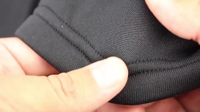 human hand testing black synthetic thermal underwear, closeup(macro)