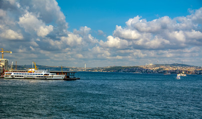 Touristic landmarks from sea voyage on Bosphorus. Cityscape of Istanbul at sunset - old mosque and turkish steamboats, view on Golden Horn.