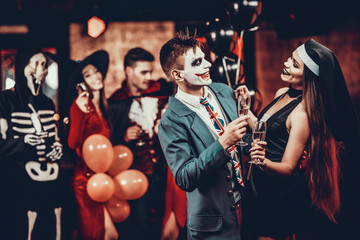 Young Smiling Couple in Halloween Costumes Dancing