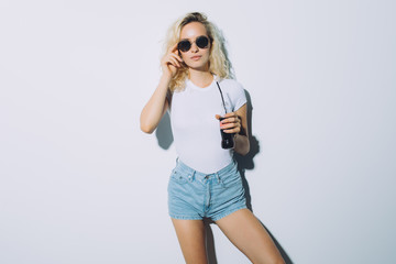 Portrait of blonde woman girl drinking soda cola from bottle