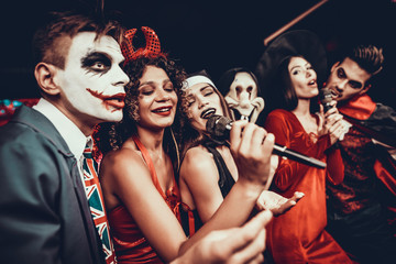 Young People in Halloween Costumes Singing Karaoke