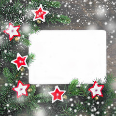 Fototapeta na wymiar Christmas decoration with red and wight felt stars, snowflakes, golden bells near fresh natural branches of spruce on brown wooden background.Top view.Flat lay.copy space