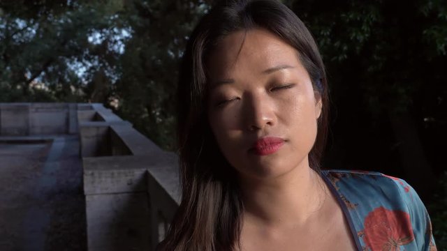 close up portrait of Young relaxed happy attractive asian woman in the park