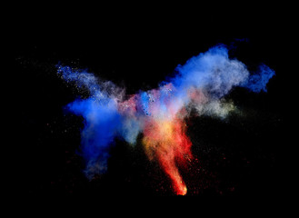 Obraz na płótnie Canvas Bizarre forms of powder paint and flour combined together explode in front of a black background to give off fantastic multi colored cloud forms.