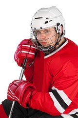Male ice hockey player in helmet holding hockey stick on a white