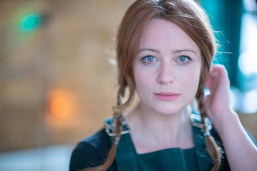 Portrait of white skin ginger girl with blue eyes with braids