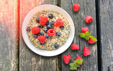 Bowl with oatmeal and fruits on wooden table