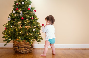 Toddler boy playing under the Christmas tree