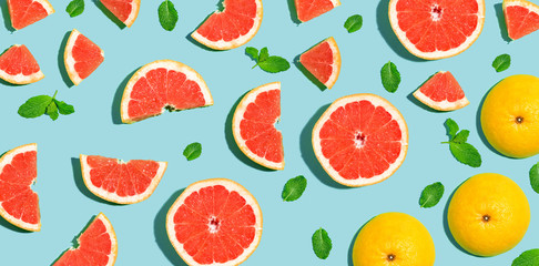 Halved fresh grapefruits on bright color background