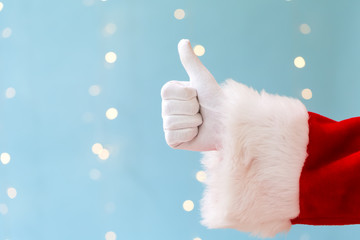 Santa giving thumb up on a shiny light blue background