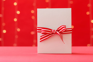 Christmas gift box on a shiny light red background