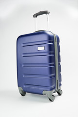 Maleta rígida de viaje azul con ruedas en fondo blanco