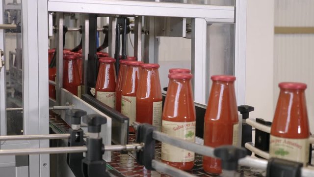 Tomato Sauce industrial production. Bottles on conveyor belt