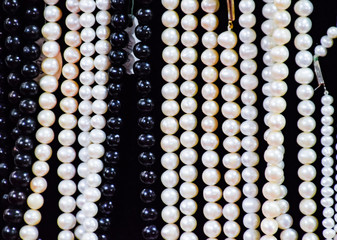 White and black pearls on a black background.