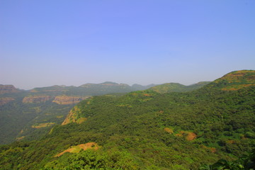 View of the forests and hills of the western ghats of Maharashtra, India with hills in the background.