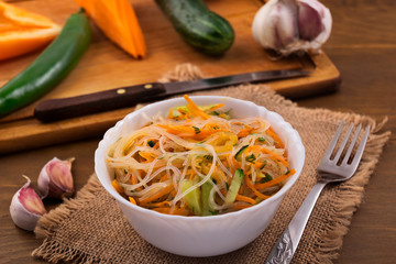 A delicious dessert made from rice noodles with vegetables, a fork on a napkin from flax.