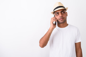 Young Indian tourist man wearing hat against white background