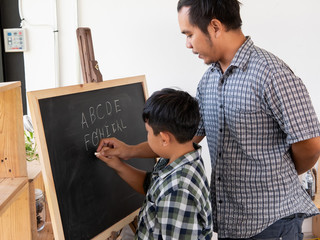  My father and the boys are helping us write the chalkboard. Education concept.