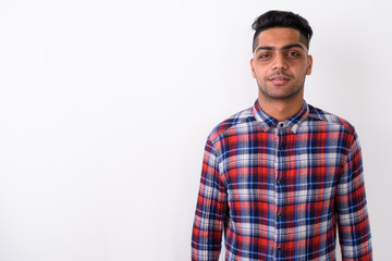 Young Indian man wearing checkered shirt against white backgroun