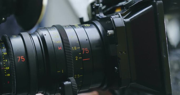 Operator turns focus ring on lens with a matte box