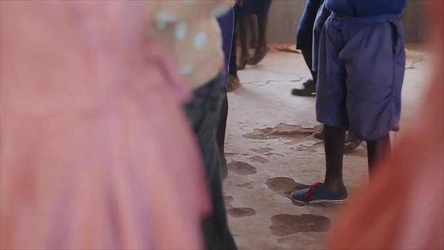 Close-up view of dancing children legs, feet. African boys and girls in school.