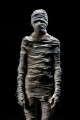 Someone in peices of cloths as mummy cosplay on black background. Concept for funny costume in halloween festival.
