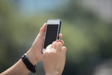 Hands using smartphone in modern city