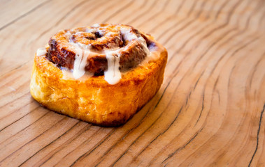 Fresh Baked Cinnamon Bun on a Wooden Table