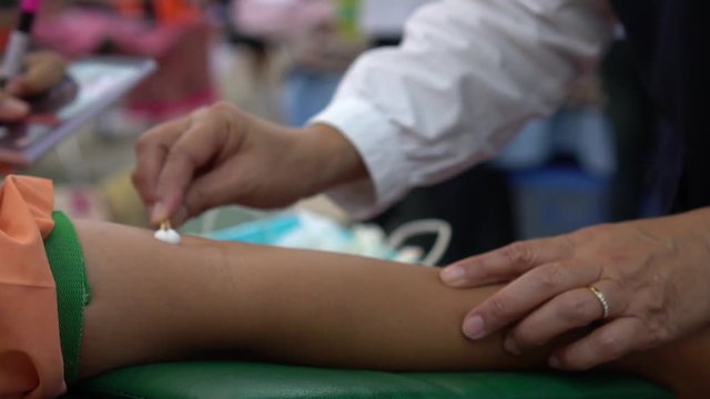 Health and Medical concept. Closeup Hands nurse are using needle to pierce vein Preparation for blood test on table. Blood donation occurs when person voluntarily has blood drawn used for transfusions