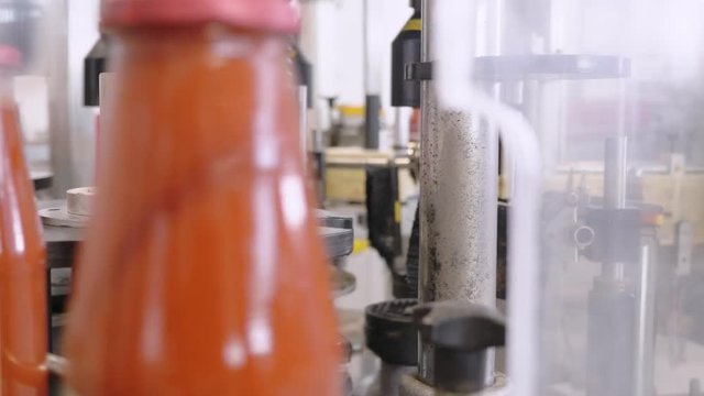 Machinery putting caps on Tomato sauce bottles.Tomato sauce factory