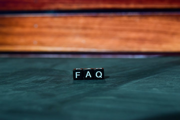  FAQ on wooden blocks. Cross processed image with bokeh background