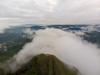 Aerial view of nature scenery. An aerial shot of hill with cloudy and misty background.