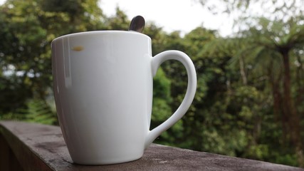 cup of coffee on wooden table in garden