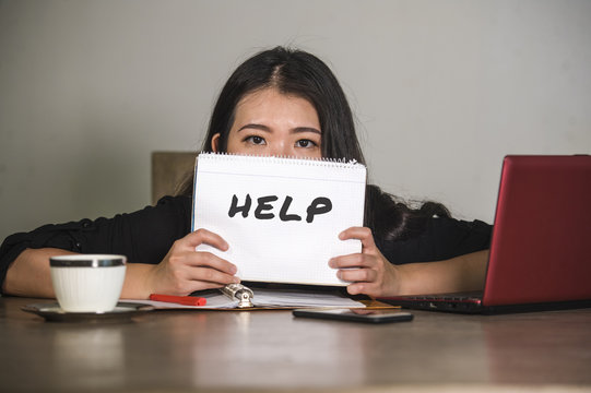 young stressed and depressed Asian Chinese businesswoman working overwhelmed and exhausted as corporate business employee asking for help desperate