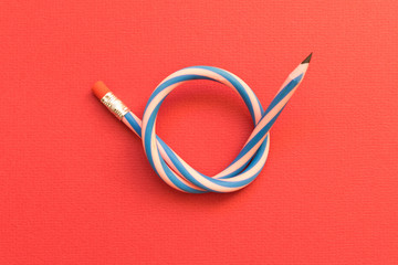 Flexible pencil . Isolated red background