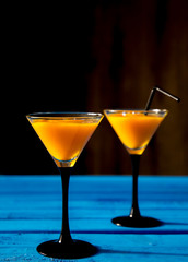 orange cocktail for halloween in high martini glasses