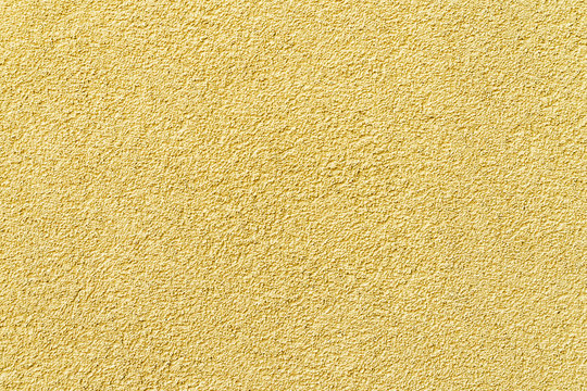 Texture of yellow decorative volumetric plaster as a background