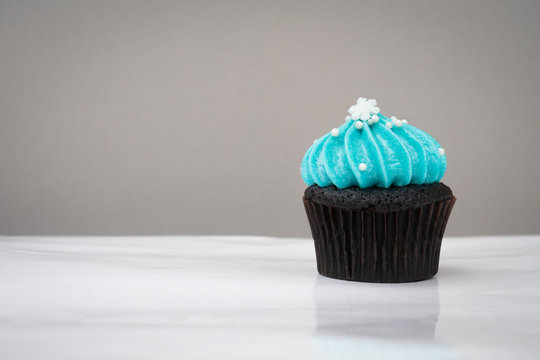 cute cupcake with small white snow blue cream on white background