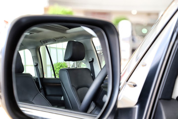 Car mirror and the reflection in it of the interior of the car