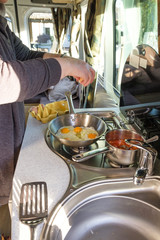 Cooking a breakfast of eggs and beans in a campervan