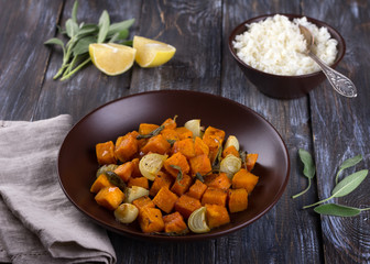 Baked pumpkin with onions, garlic and sage with boiled rice on a wooden table. delicious healthy homemade food