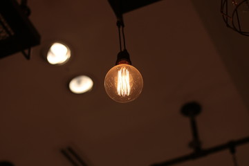 A electric lamp lighting . modern and vintage style , interior ceiling hanging light bulb decorate at room