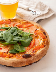 Traditional home made thin crust pizza with spinach, tomato, and mozzarella. Copy space.