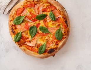 Traditional home made thin crust pizza with spinach, tomato, and mozzarella. Copy space.