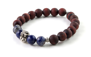Unpolished red tiger's eye stone bracelet with sodalite gemstone and silver owl figurine isolated on white background