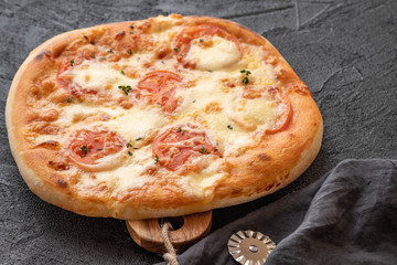 Pizza Margherita on black stone background. Homemade Pizza Margarita with Tomatoes and Mozzarella Cheese.