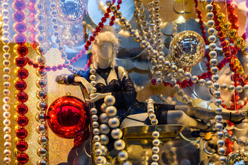 Female mannequin dressed in black lingerie and different christmas decorations in a showcase