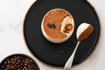 Delicious Italian dessert tiramisu, chocolate, cocoa and coffee beans on a black background. Copy...
