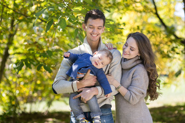 Naklejka na ściany i meble family with a baby in autumn park
