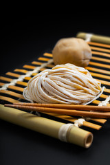 Food fresh raw homemade oriental Asian, Chinese egg noodles by organic eggs and all purpose flour on a bamboo tray